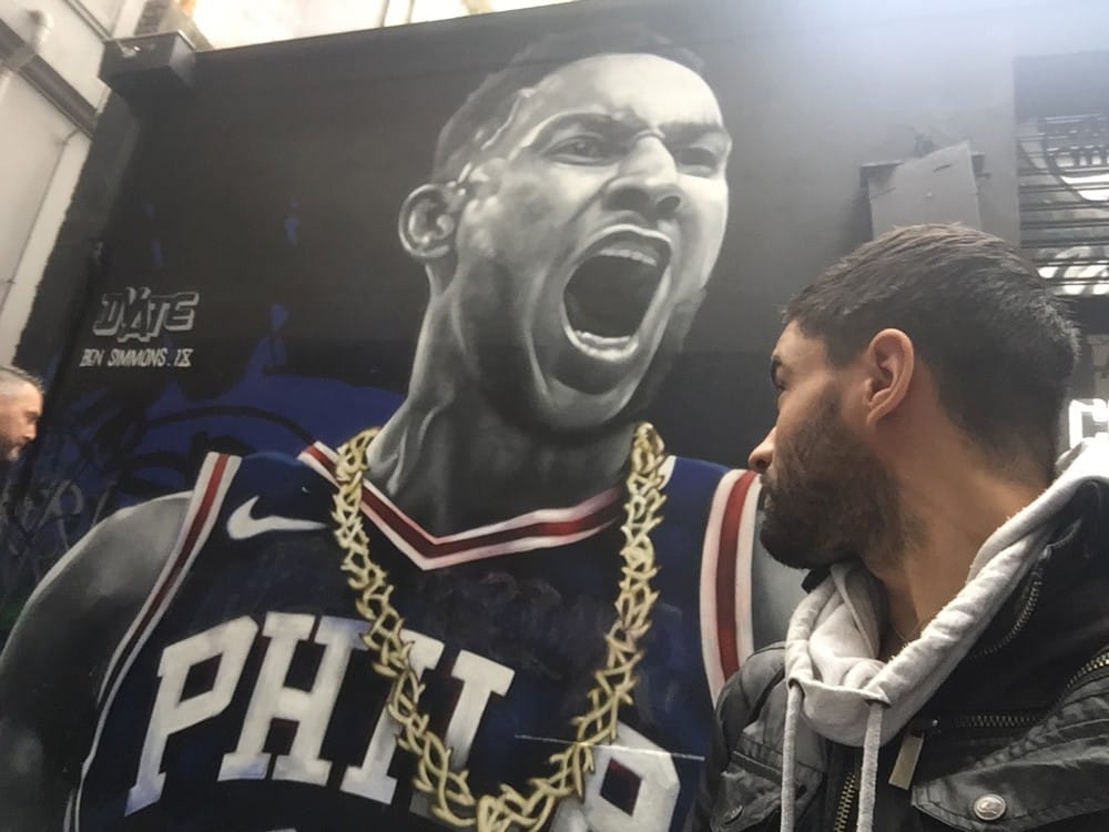 Vivir en Melbourne chico mirando de perfil a un jugador de la liga de baloncesto en una fotografía